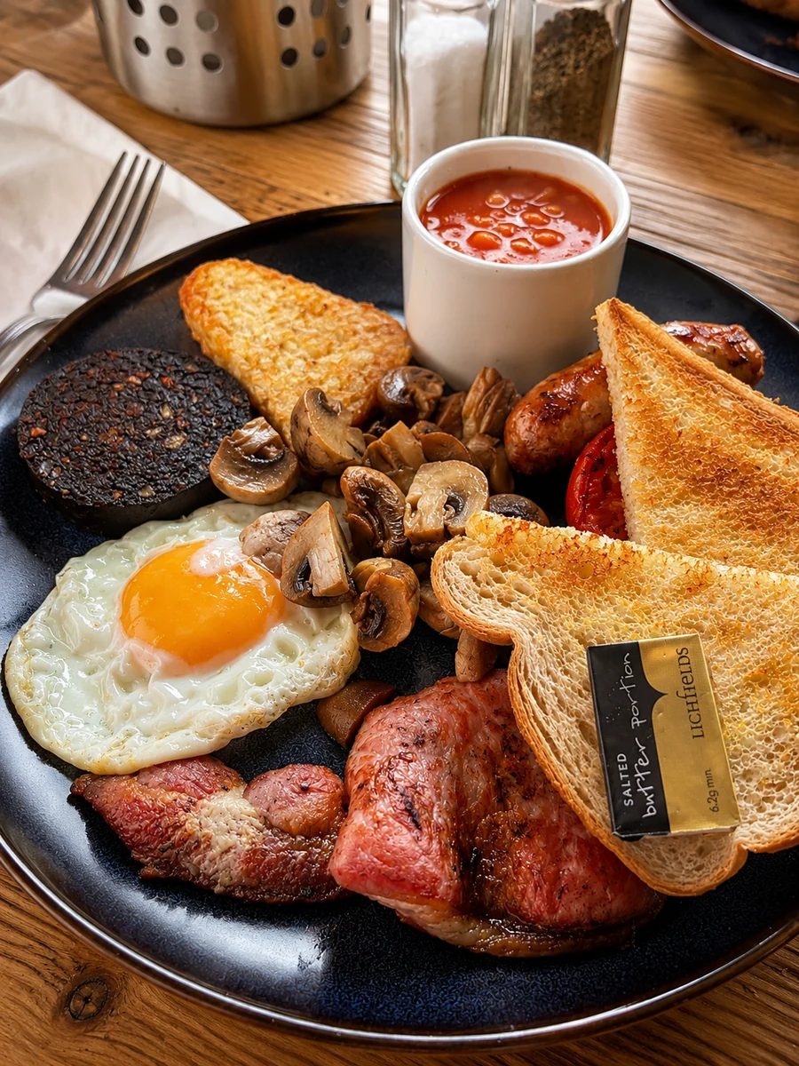 A full breakfast plate with eggs, beans, toast and mushrooms